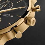 Gold watch with black dial on a dark background