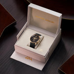 Magnum Gold chronograph with black dial and textured rubber strap presented in a beige Matthew Mercury box on a dark wood surface.