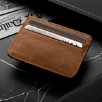Brown leather wallet with a credit card on a black marble surface